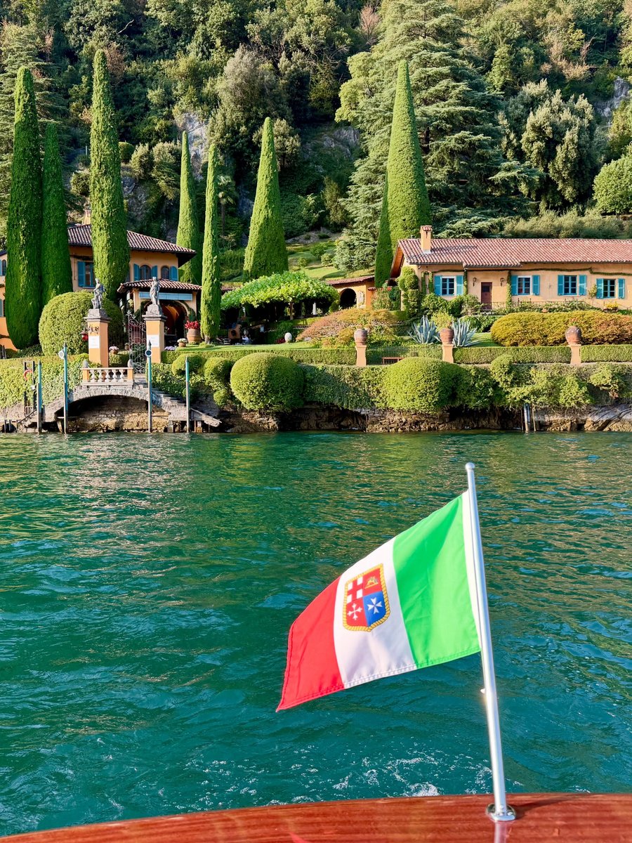 A lakeside villa, cypress trees standing at attention